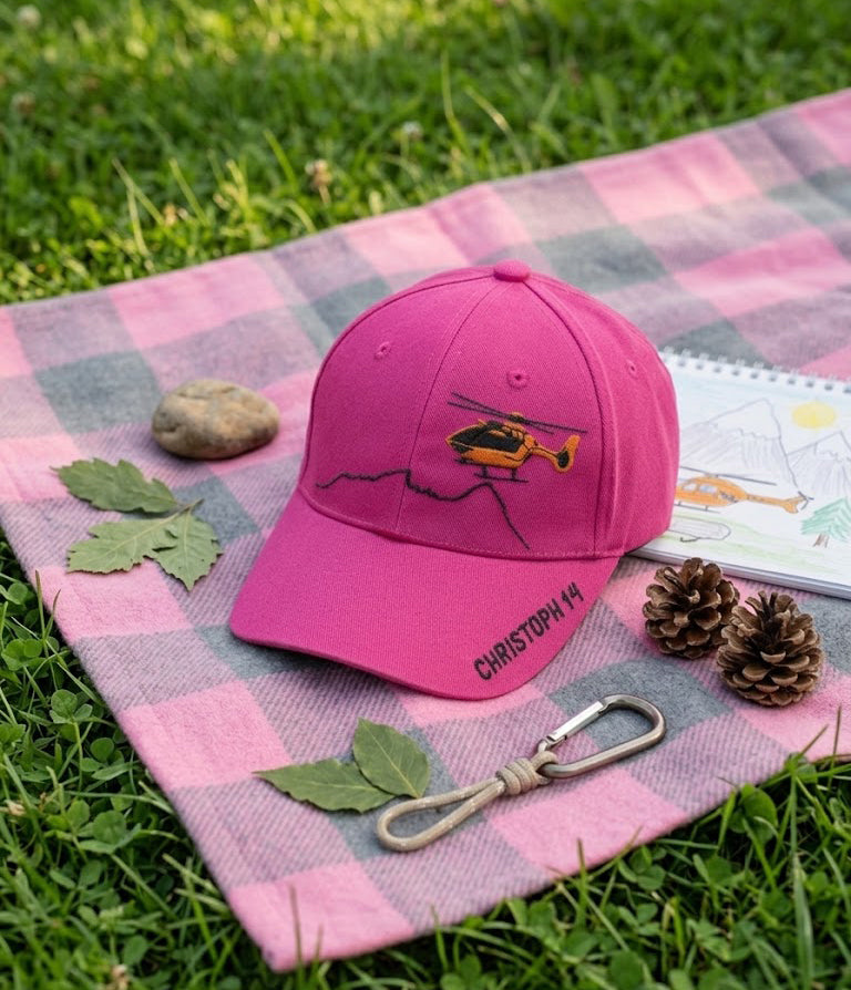 Cap pink für Kinder, auf einer Picknickdecke auf einer Wiese, zusammen mit Naturmaterialien, Malblock und Karabiner