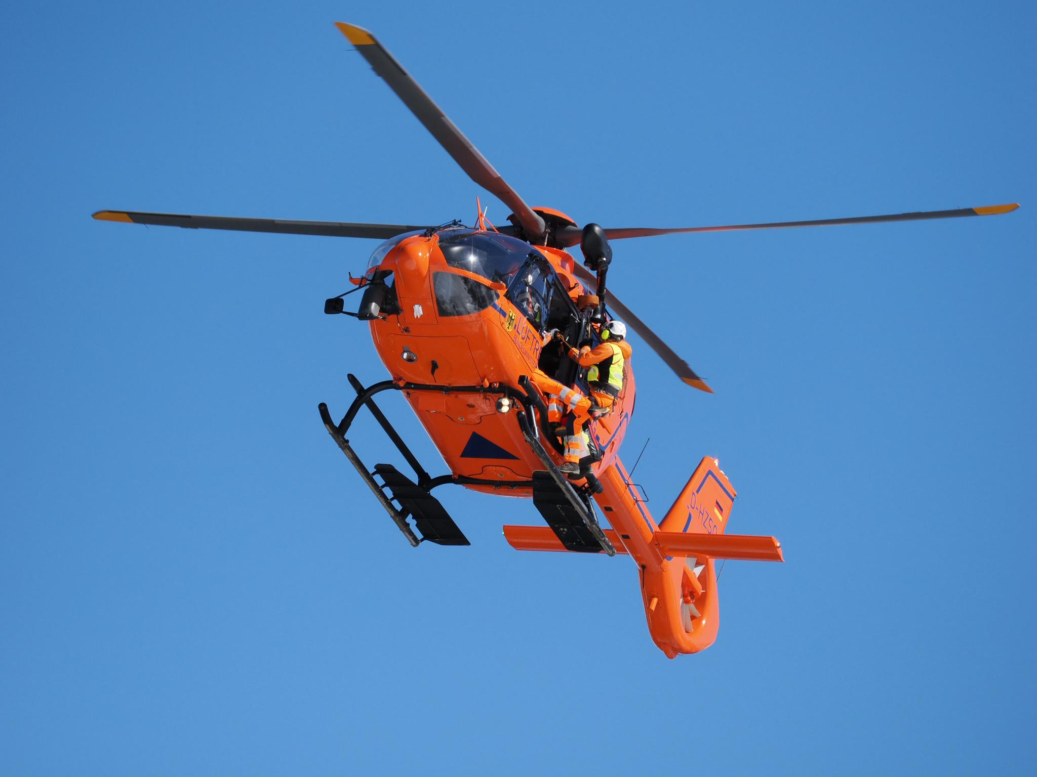 Hubschrauber Christoph 14 in der Luft vor blauem Himmel