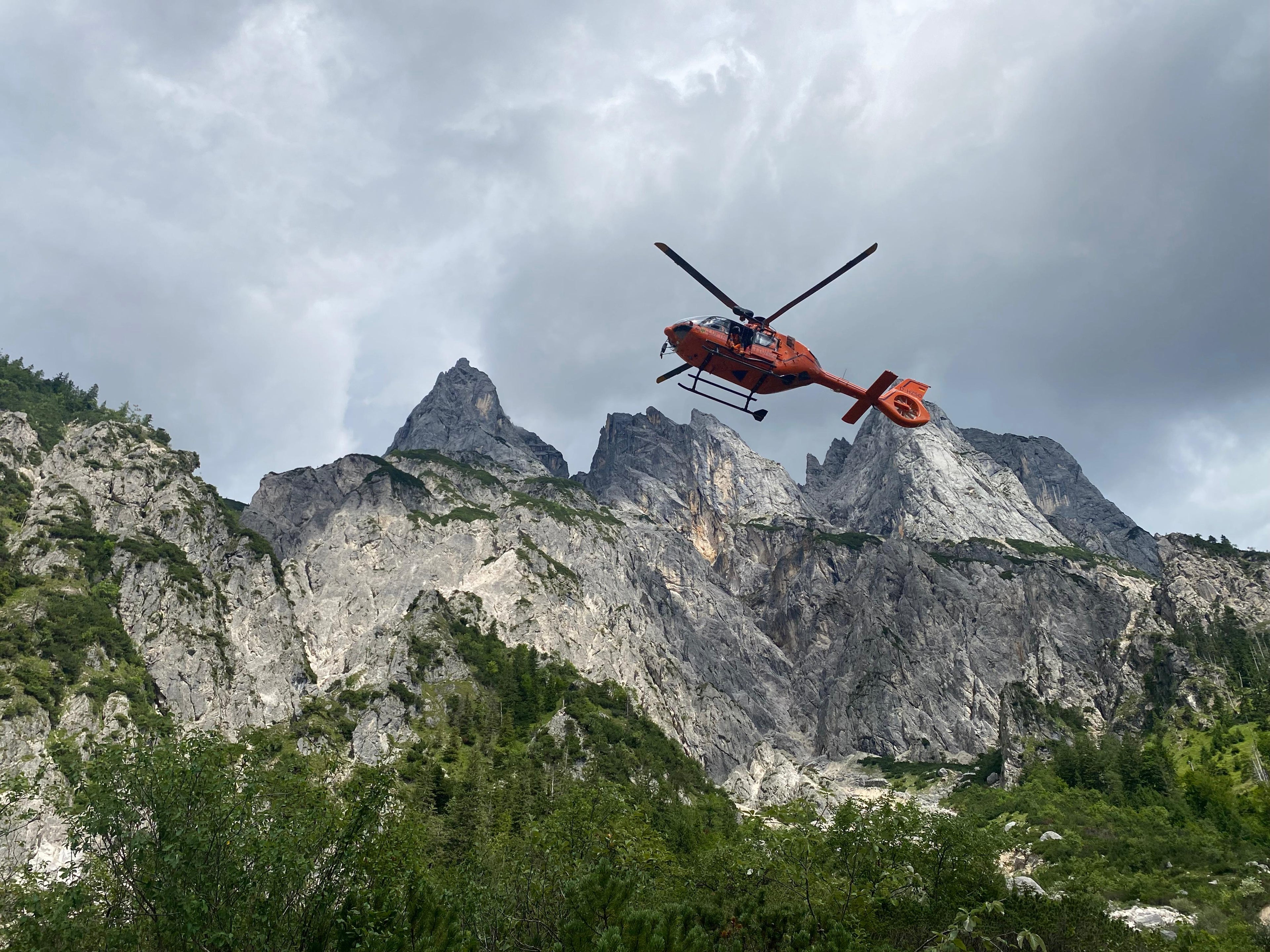 Rettungshubschrauber Christoph 14 über Bergsilhouette im Klausbachtal-Ramsau. Foto von Bergwacht Ramsau